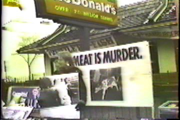 Protest in front of McDonalds. One sign reads: Meat is Murder.